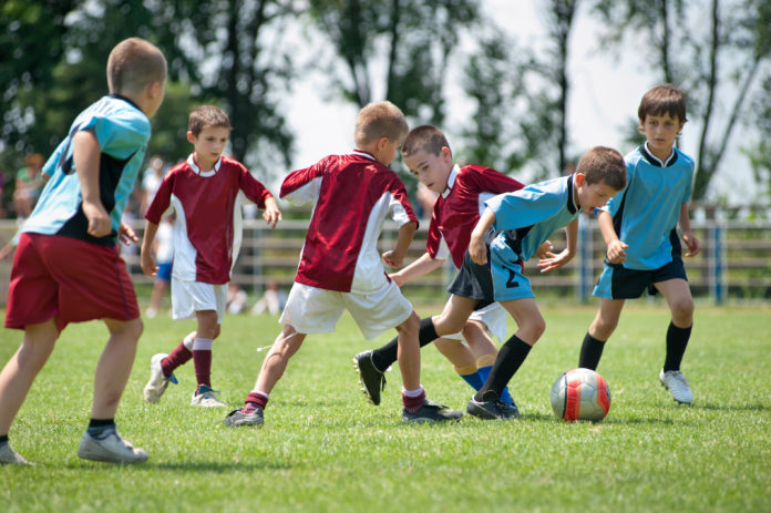kids playing football outside Perché i bambini devono giocare e fare sport - sport attività bambini