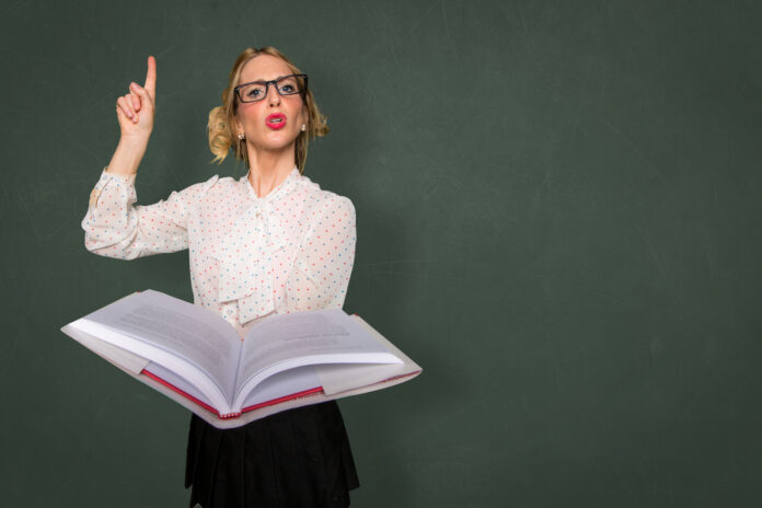 Smart nerd teacher substitute lecturing class with text book in classroom space for print