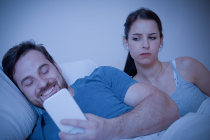 Suspicious girl trying to read messages on the mobile phone of her boyfriend Tradimento on line