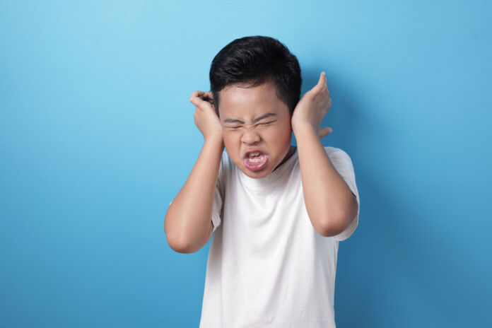 Asian boy screaming and close his ears, don't want to hear Aiutiamo i nostri figli a crescere