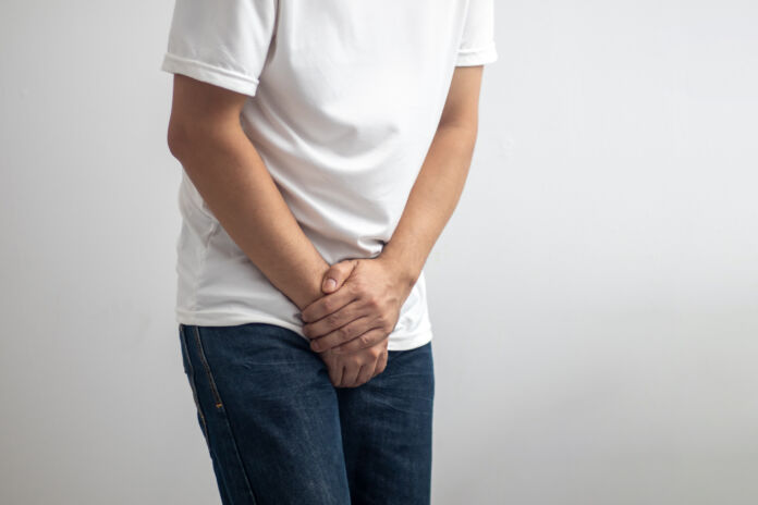 The man touched the crotch of his pants with pain.