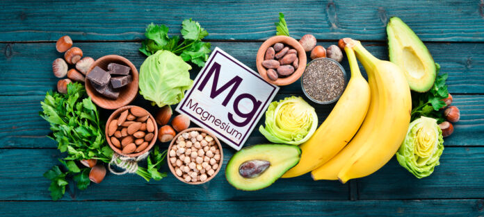 Foods containing natural magnesium. Mg: Chocolate, banana, cocoa, nuts, avocados, broccoli, almonds. Top view. On a blue wooden background. Magnesio